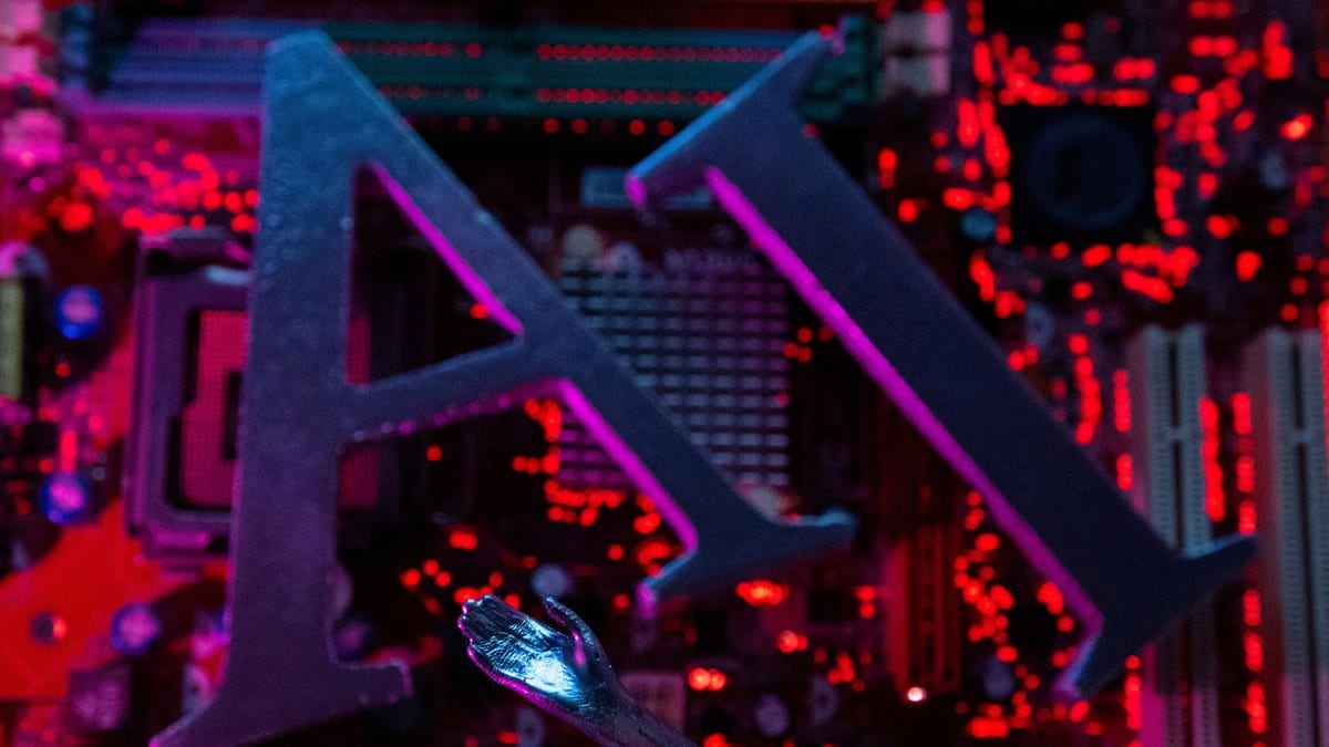 Robot hand touching computer motherboard with AI letters
