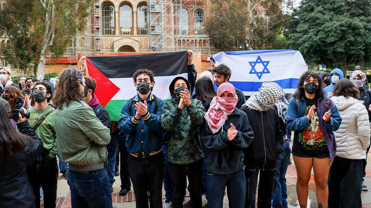 Protesters stand in front of Israeli and Palestinian flags at UCLA