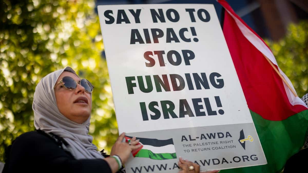 A woman holding a sign saying Say No To AIPAC Stop Funding Israel at a pro-Palestinian rally in Los Angeles
