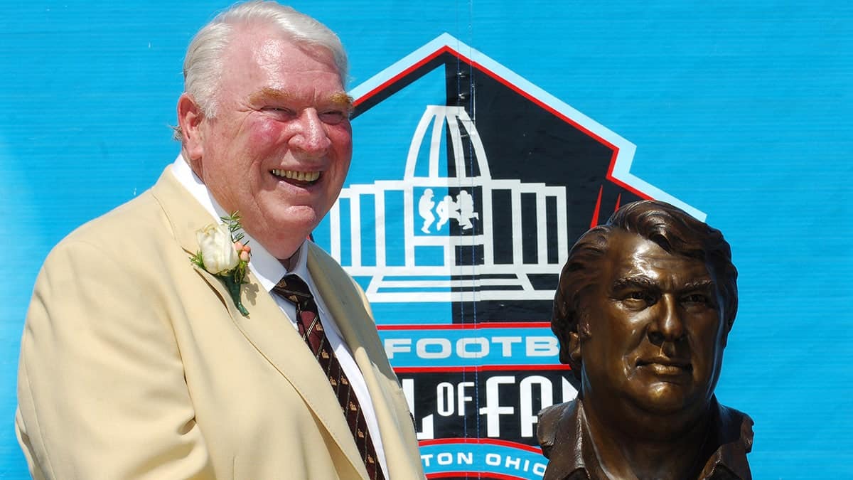 John Madden posing with a bust at the NFL Pro Football Hall of Fame enshrinement in Canton, Ohio