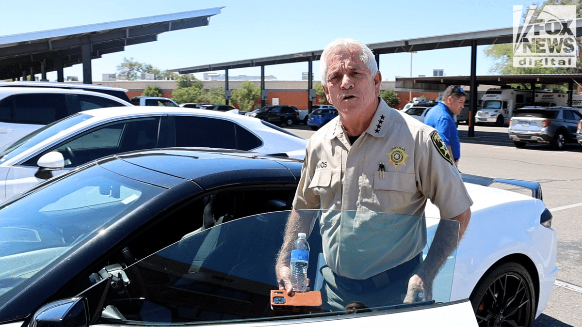 Pima Sheriff Chris Nanos in uniform entering his white Corvette at the PCSD HQ in Tucson