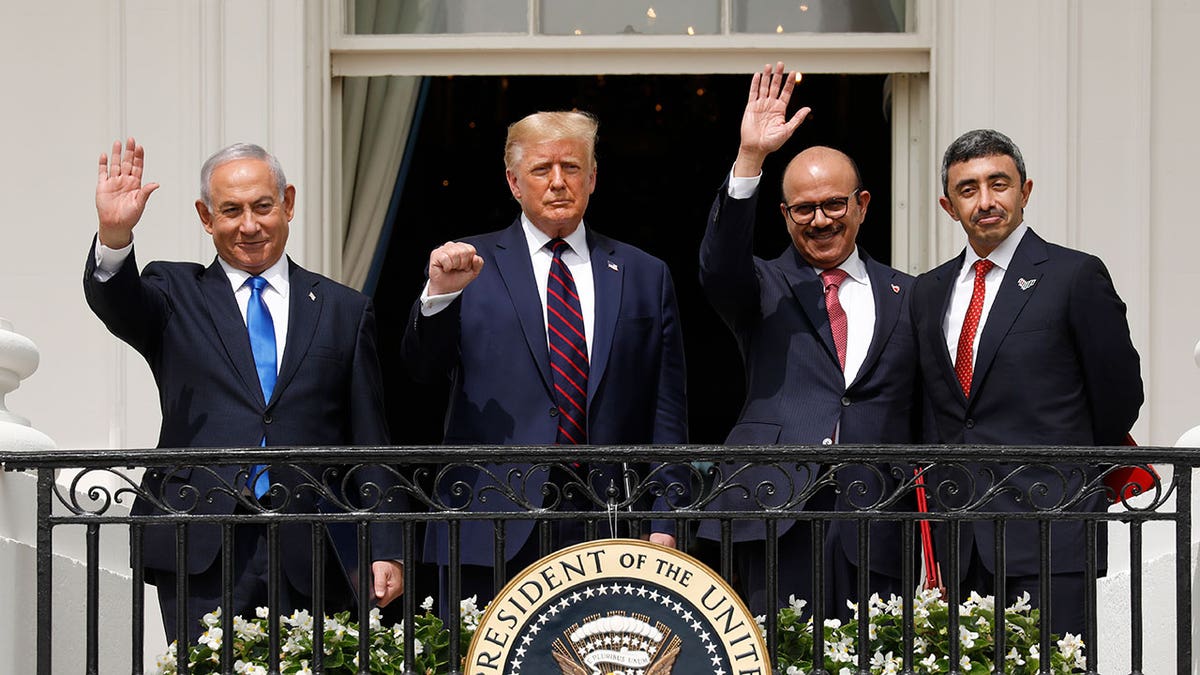Benjamin Netanyahu, Donald Trump, Abdullatif bin Rashid Al Zayani, and Sheikh Abdullah bin Zayed bin Sultan Al Nahyan standing during Abraham Accords signing ceremony.