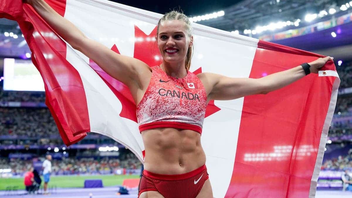 Alysha Newman holding Canadian flag celebrating pole vault bronze medal at Stade de France