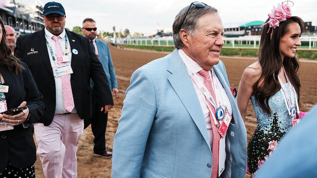 Bill Belichick and girlfriend Jordon Hudson standing on dirt track at Churchill Downs