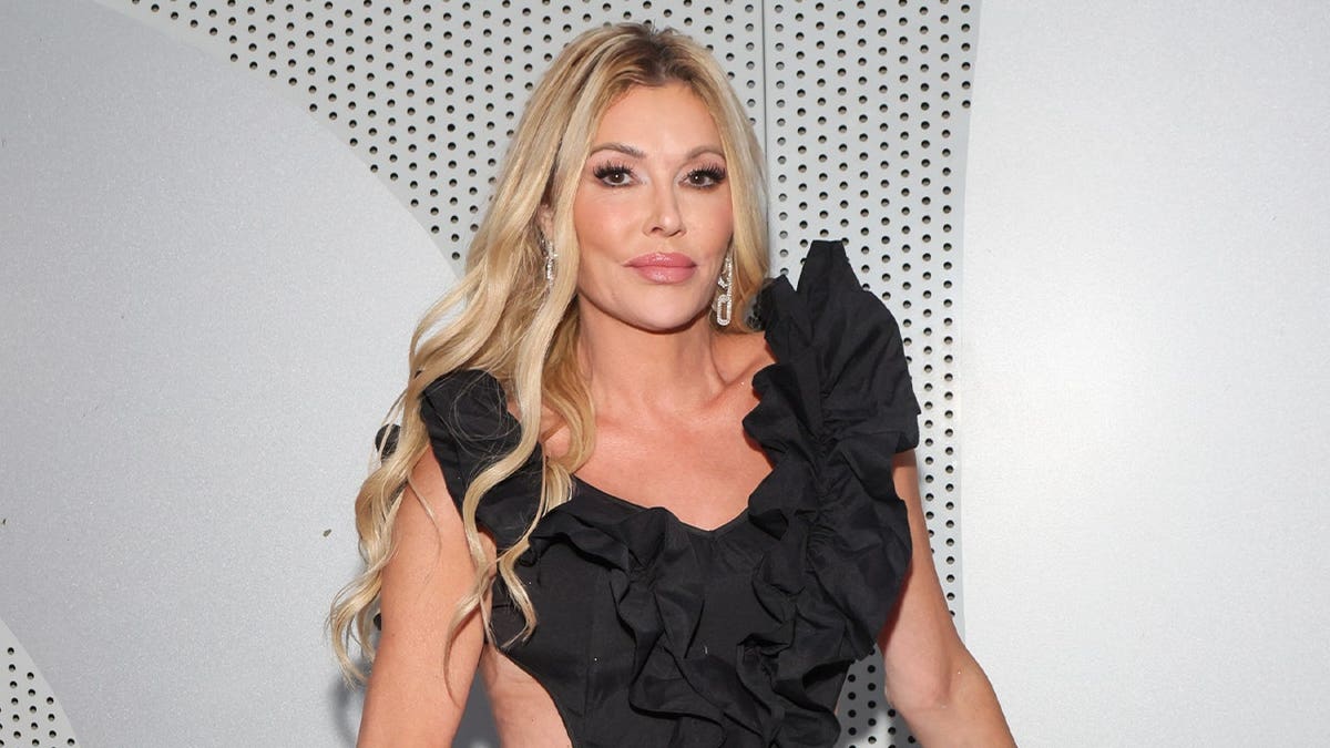 Brandi Glanville poses in a black dress