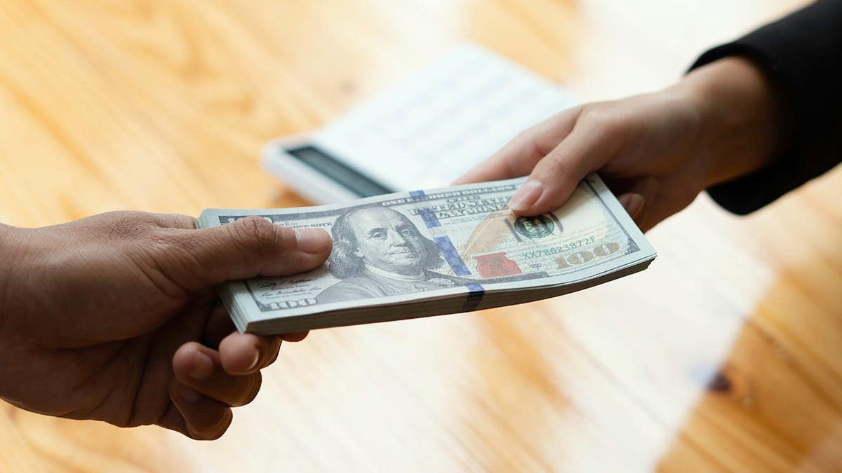 Businessman hand sending money to another business person