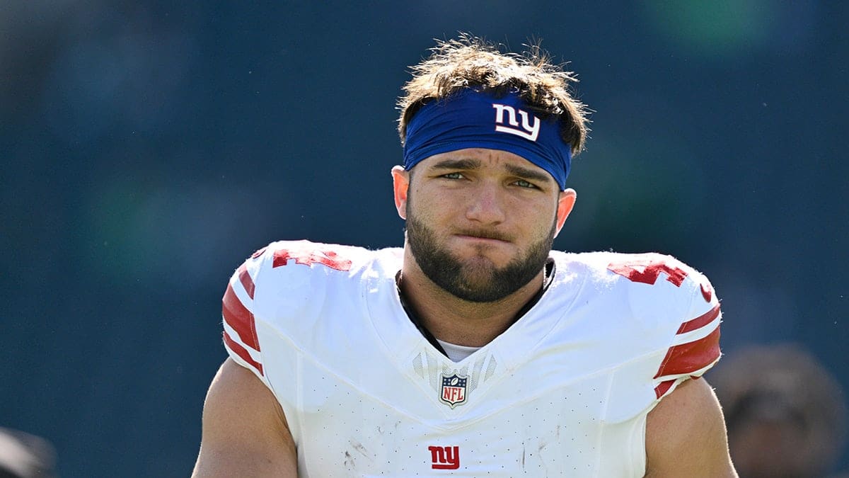 New York Giants running back Cam Skattebo warming up on the field.
