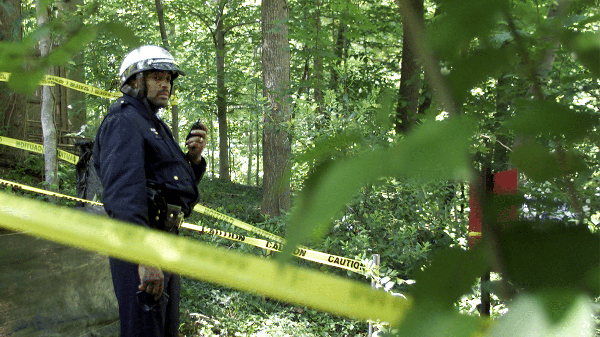 DC POLICE OFFICER STANDS IN WOODS NEAR AREA WHERE BODY WAS FOUND IN ROCK CREEK PARK