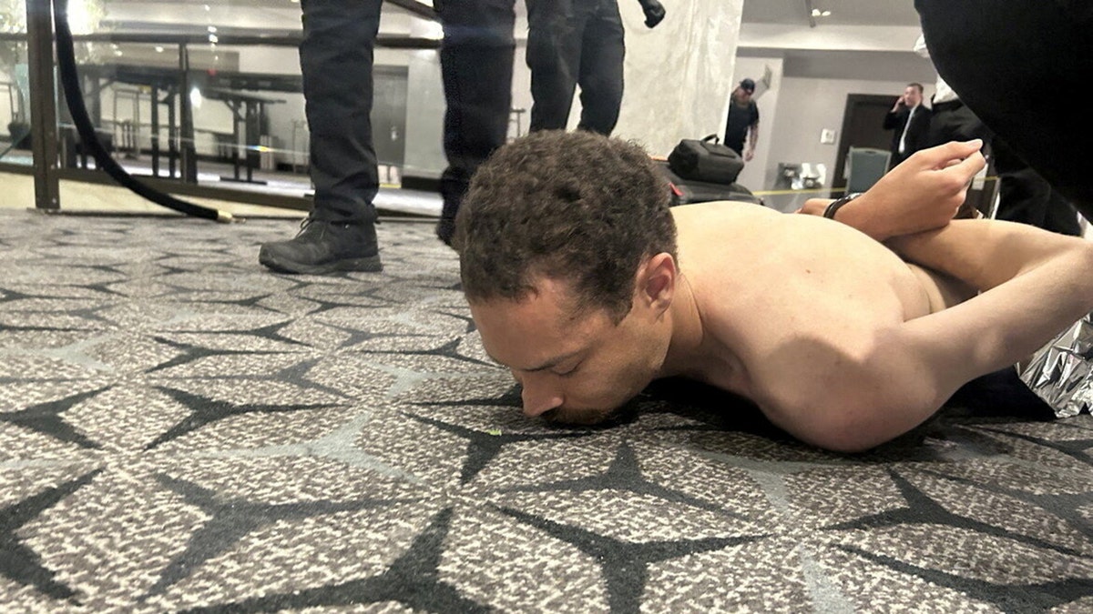 Cole Tomas Allen restrained by law enforcement after White House shooting.