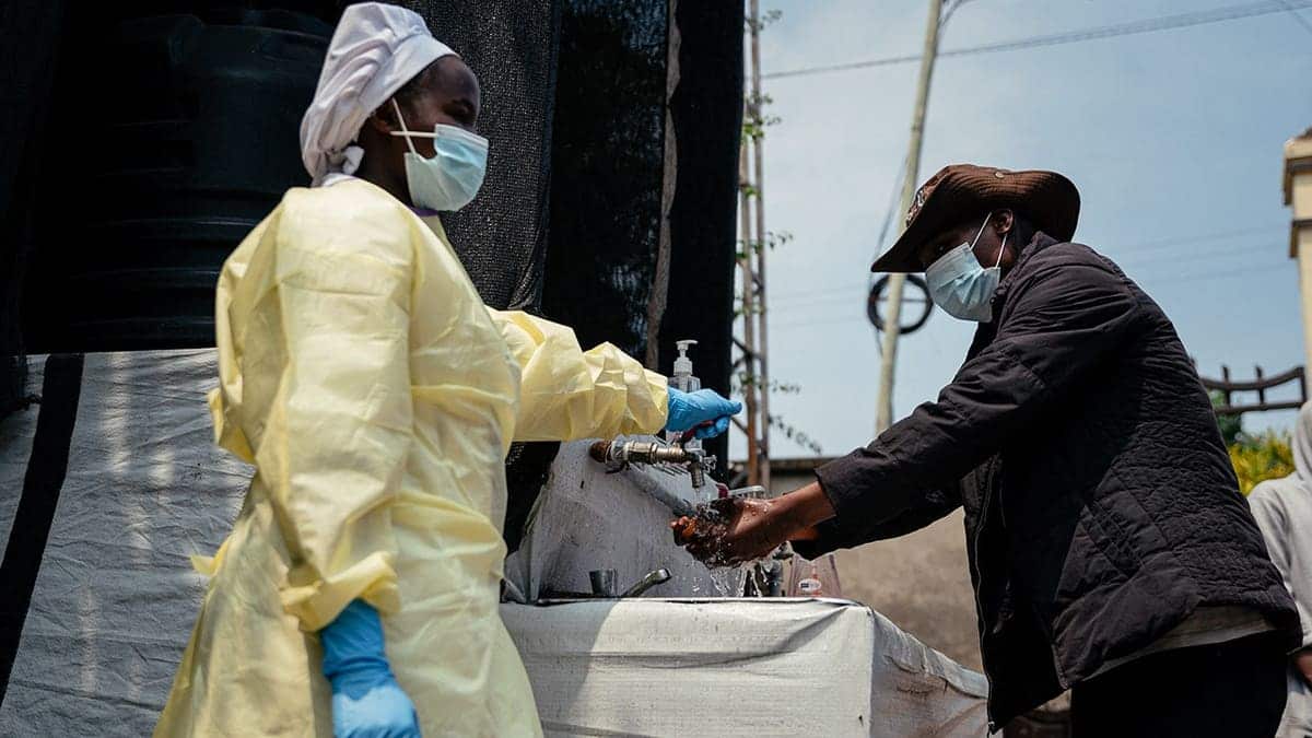 A visitor washes his hands at a checkpoint outside Kyeshero Hospital in Goma