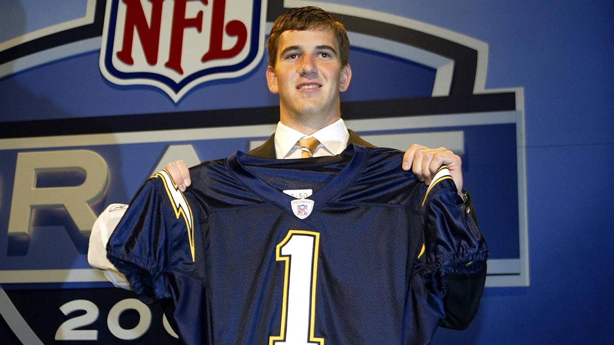Eli Manning holding up a San Diego Chargers jersey at the NFL Draft