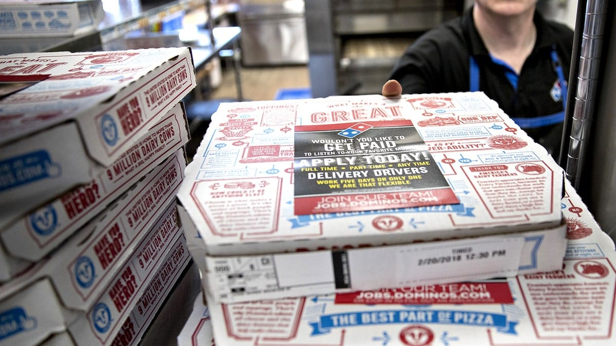 Male employee picking up Domino's boxes