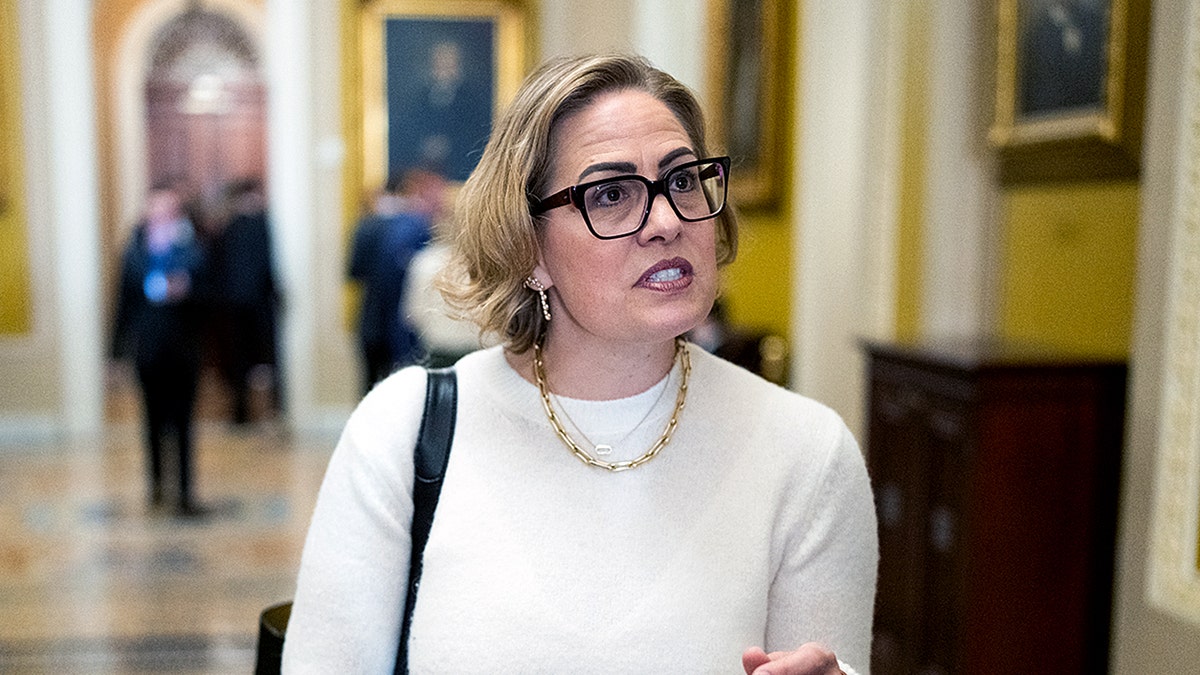 Former Sen. Kyrsten Sinema speaking to reporters in the Ohio Clock Corridor at the U.S. Capitol