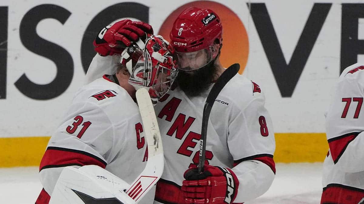 Carolina Hurricanes goaltender Frederik Andersen and defenseman Brent Burns celebrating on ice