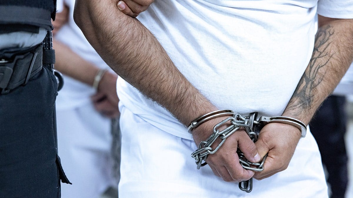 A Tren de Aragua gang member handcuffed and detained at CECOT prison in El Salvador