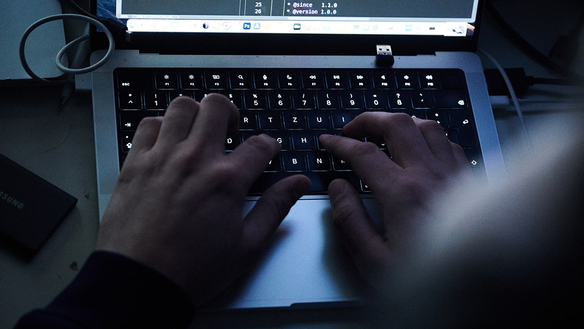 A hacker stealing information on a computer screen
