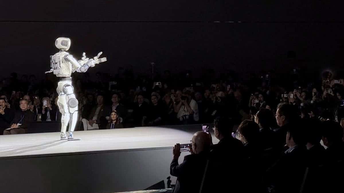 A Hyundai robot stands before a crowd.