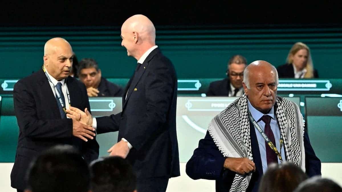 FIFA President Gianni Infantino shakes hands with Basim Sheikh Suliman (left), vice president of the Israeli Football Association, as Jibril Rajoub (right), president of the Palestine Football Association, leaves the stage at the 76th FIFA Congress in Vancouver, Canada on April 30, 2026.