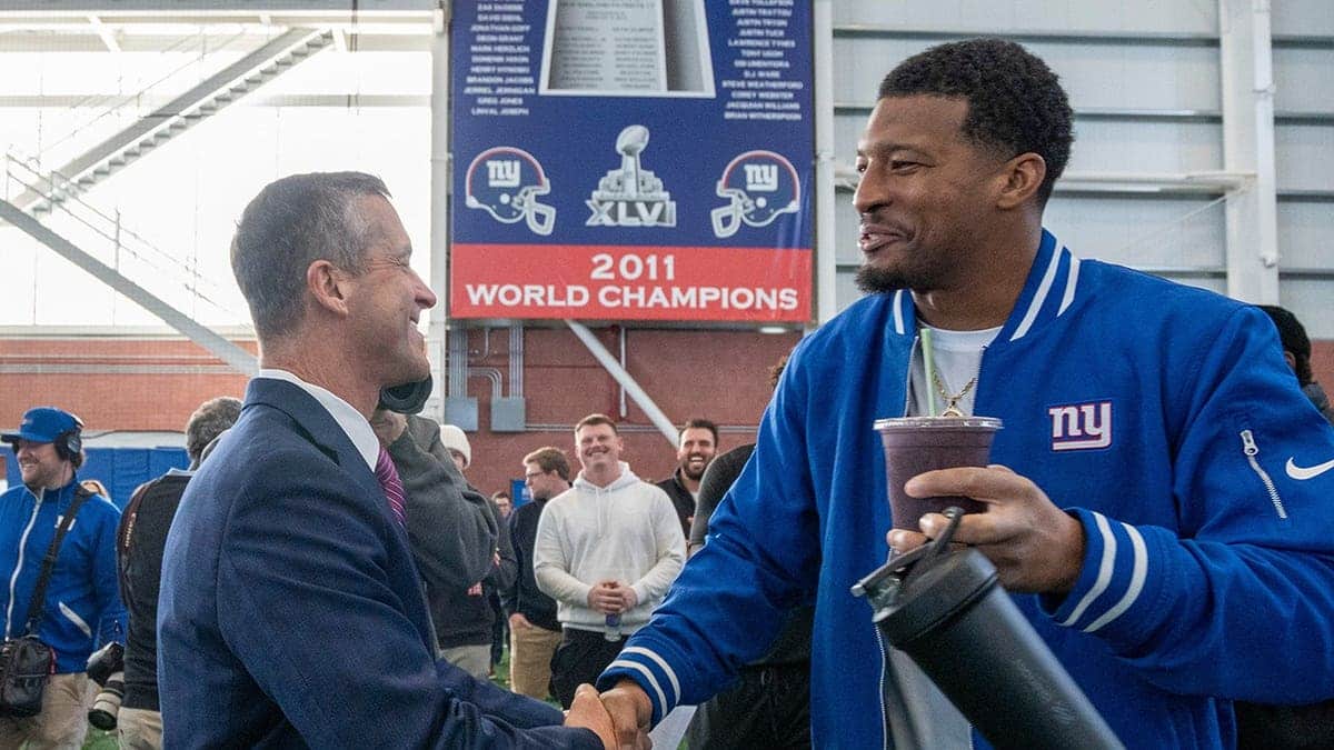 New Head Coach John Harbaugh shaking hands with New York Giants quarterback Jameis Winston at a press conference