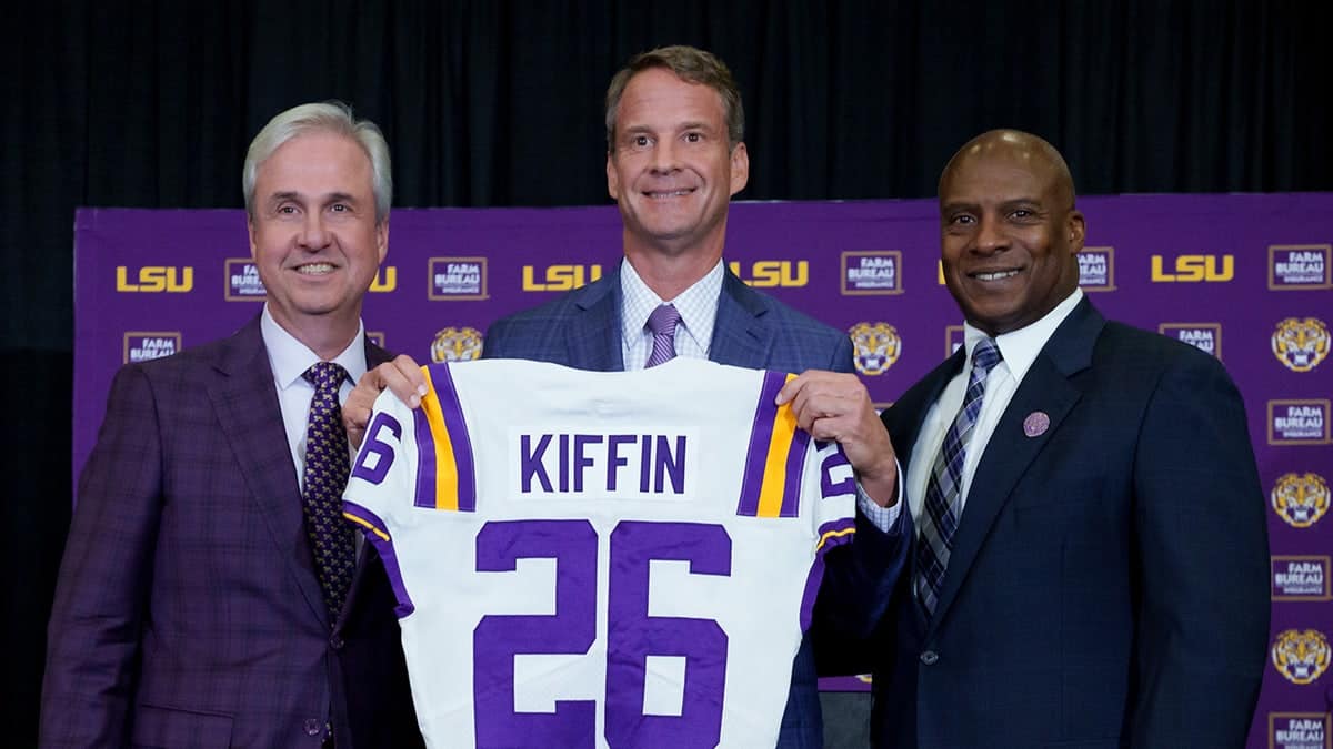 LSU president Wade Rousse, head coach Lane Kiffin, and athletic director Verge Ausberry standing together at South Stadium Club