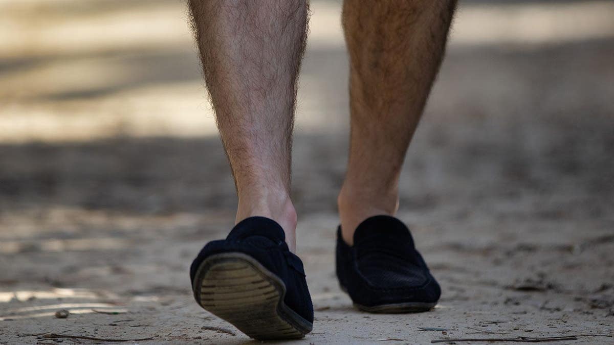 A man walking barefoot through a natural outdoor setting.
