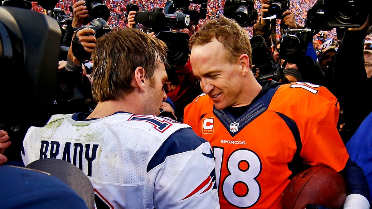 Tom Brady and Peyton Manning shaking hands and talking on football field