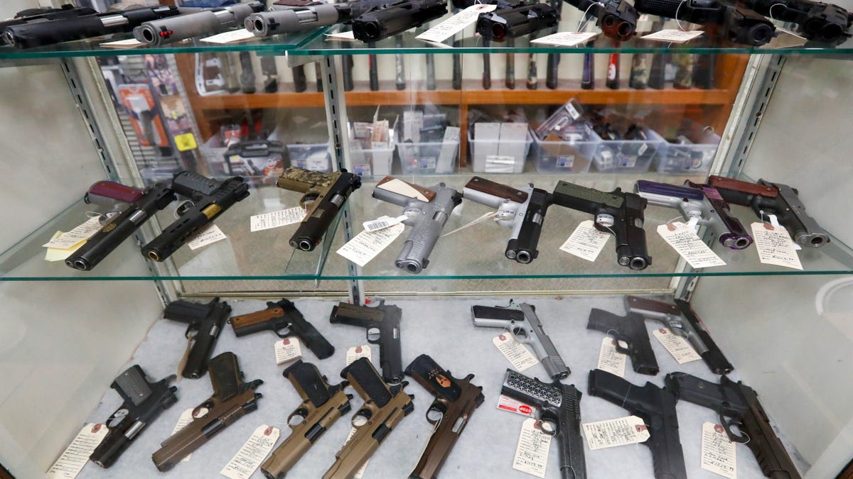 Semi-automatic handguns displayed on shelves in a gun shop in New Castle, Pa.