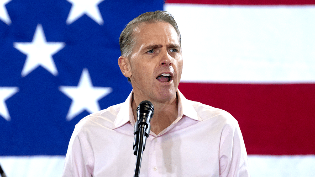 Conservative commentator Scott Jennings speaking at a podium at Ashley's BBQ Bash in Cedar Rapids, Iowa