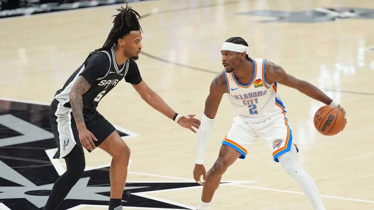 Oklahoma City Thunder guard Shai Gilgeous-Alexander dribbling basketball against San Antonio Spurs guard Stephon Castle