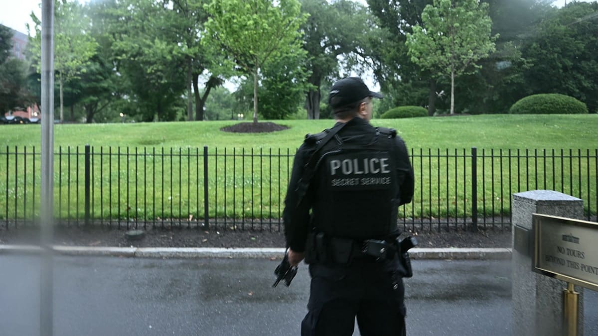 An armed Secret Service agent reacts at the White House