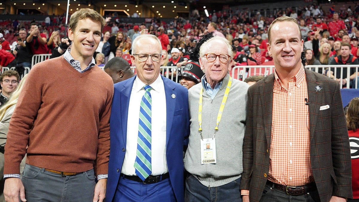 Eli Manning, Archie Manning, Peyton Manning, and SEC Commissioner Greg Sankey posing together at Mercedes-Benz Stadium