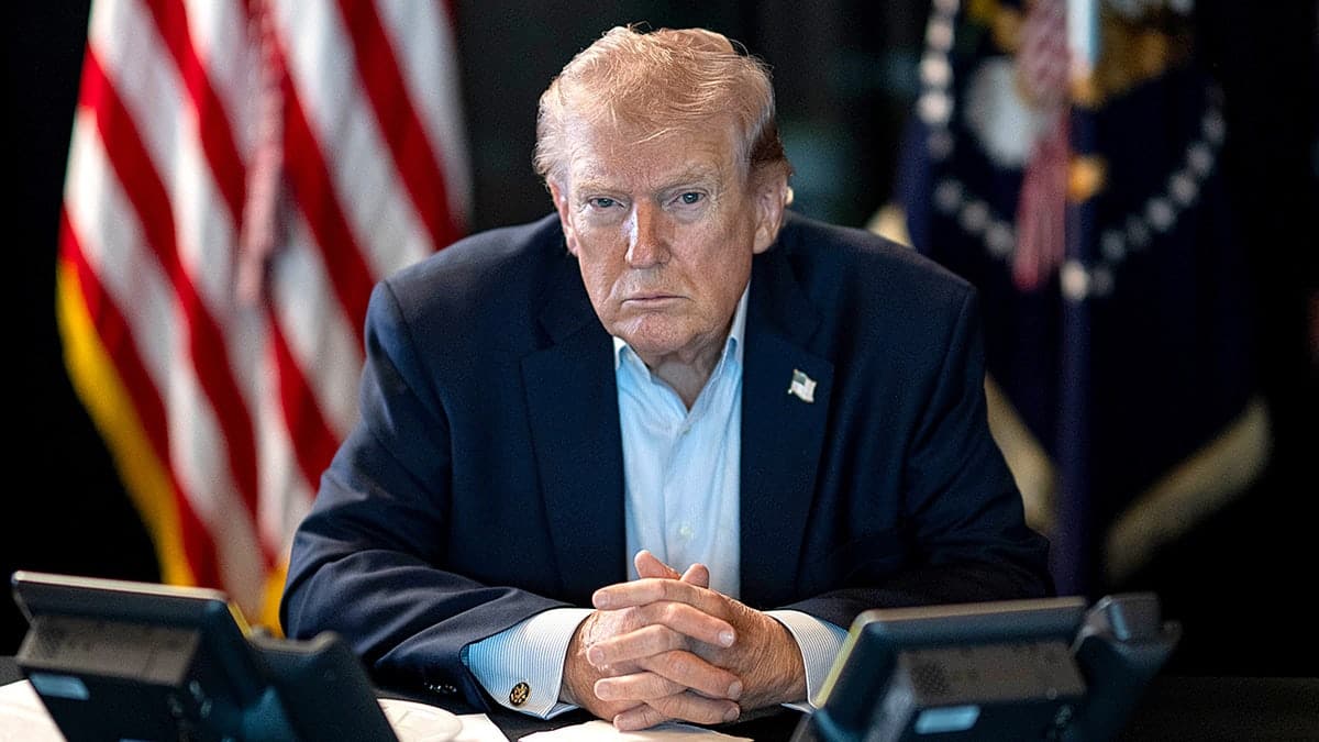President Donald Trump sitting at a table monitoring military operations in the White House
