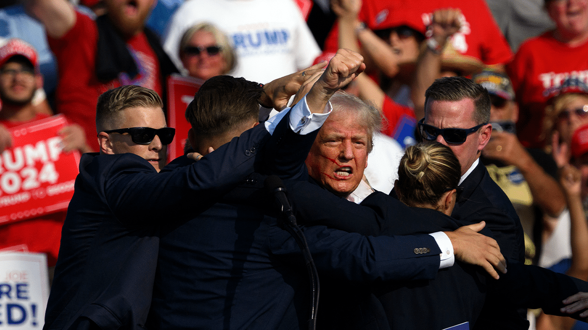 Former President Donald Trump surrounded by Secret Service agents at a campaign rally in Butler, Pennsylvania