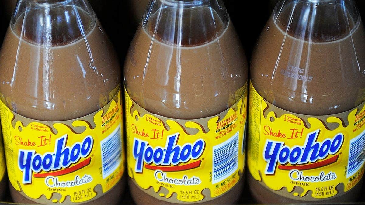 Three bottles of Yoo-hoo sit on a shelf.