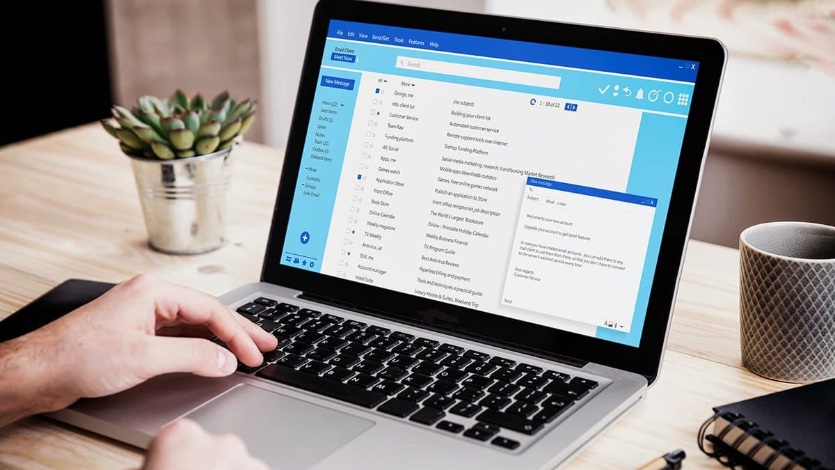 A laptop displaying an email inbox on a desk.