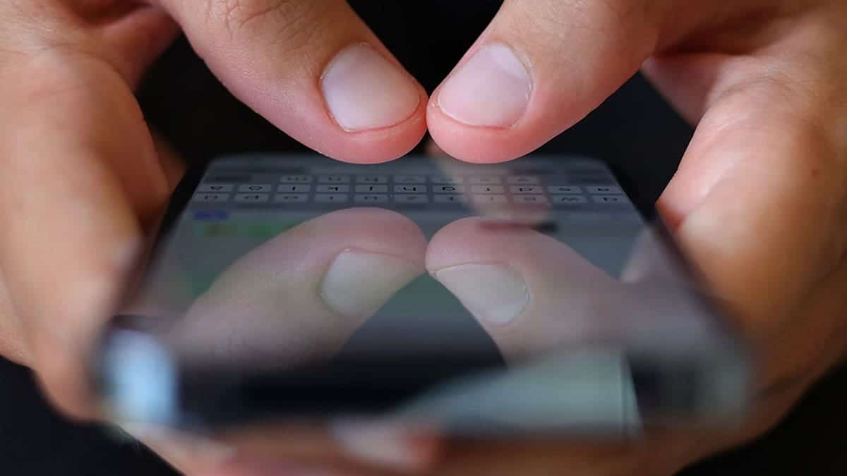 Person typing on their smartphone.