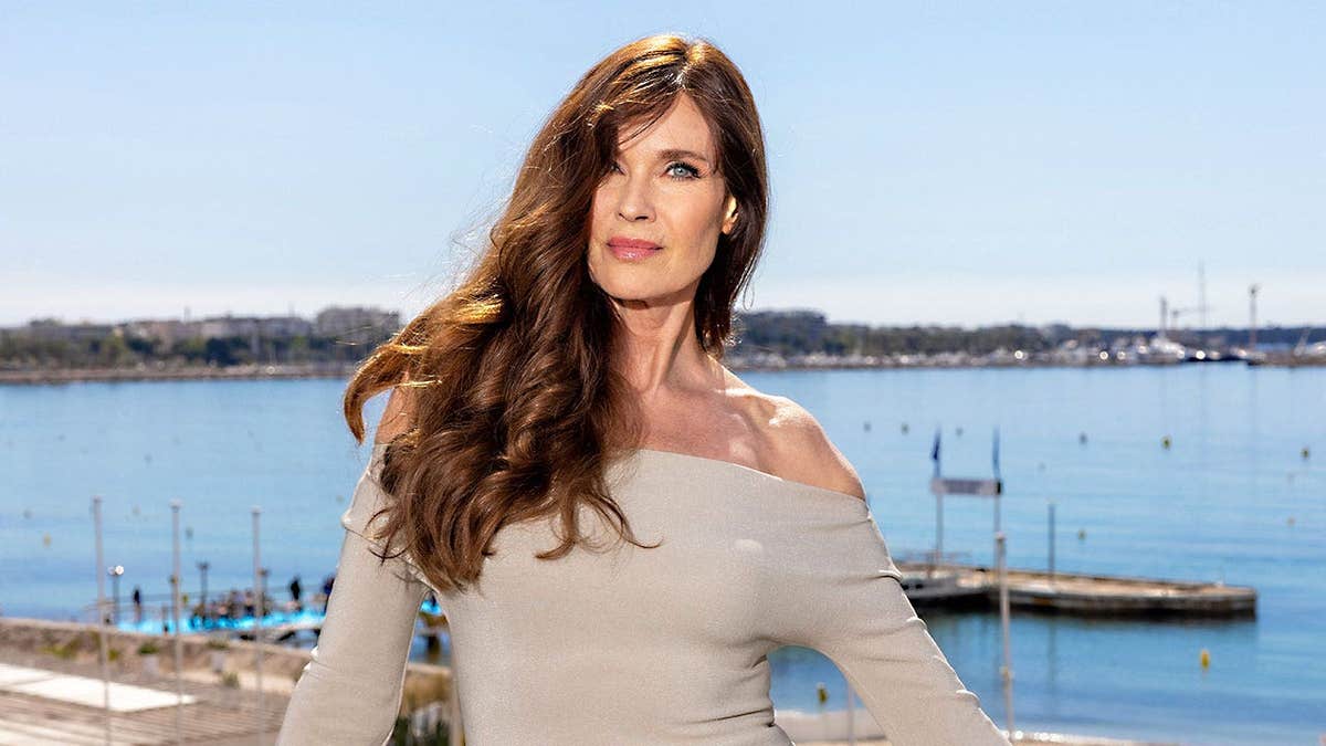 Carol Alt wearing a beige off the shoulder sweater in Cannes, France.