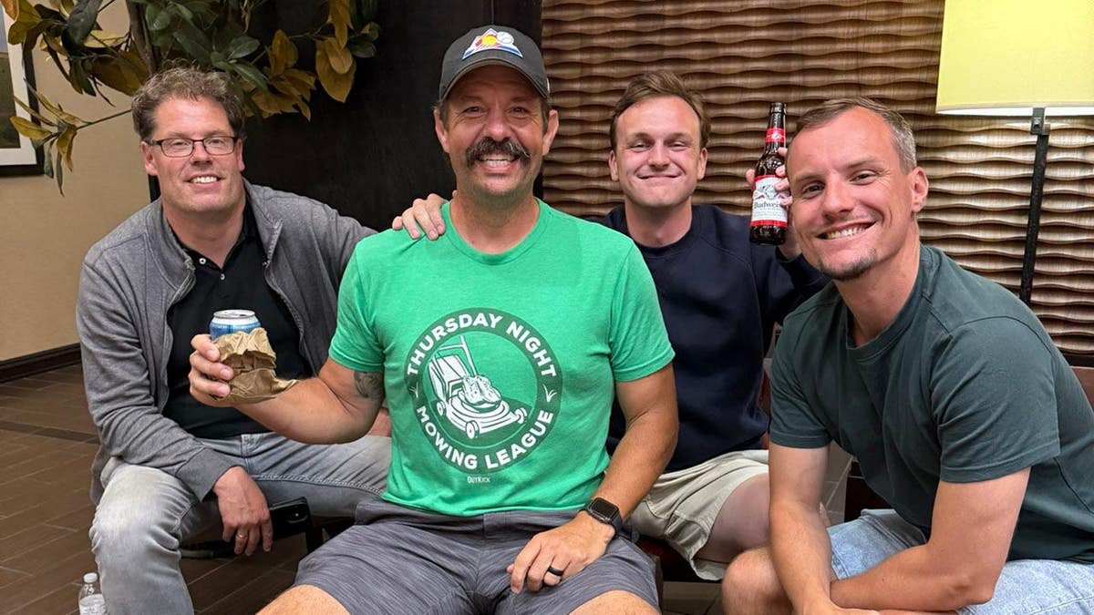 2024 Thursday Night Mowing League champion Fink smiles while being joined with members of Dutch media