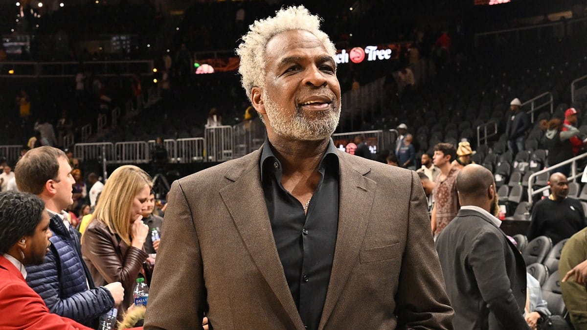 Retired NBA star Charles Oakley sitting courtside at a basketball game.