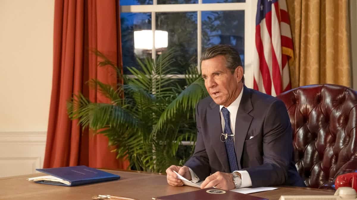 Dennis Quaid portraying President Ronald Reagan seated in the Oval Office.