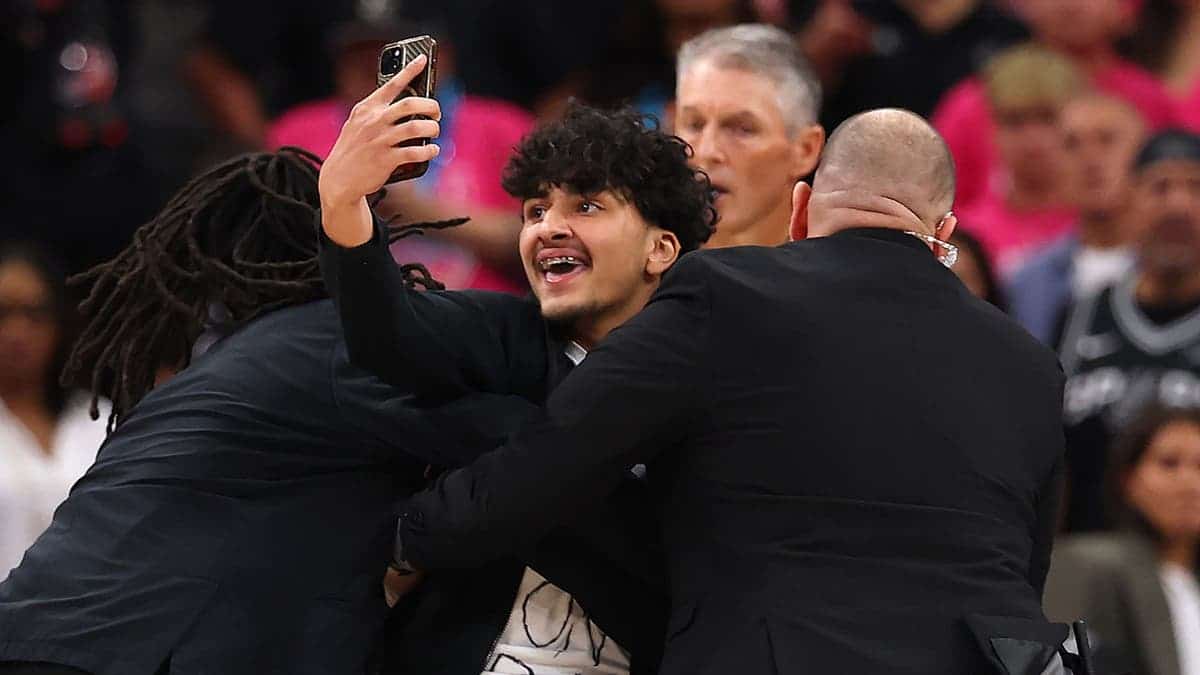 Fan being detained by security on basketball court