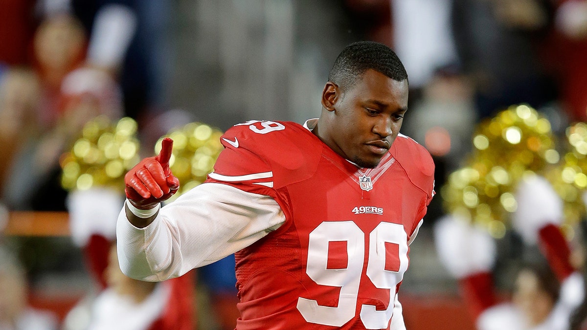 Aldon Smith #99 of the San Francisco 49ers running on the field at Levi's Stadium
