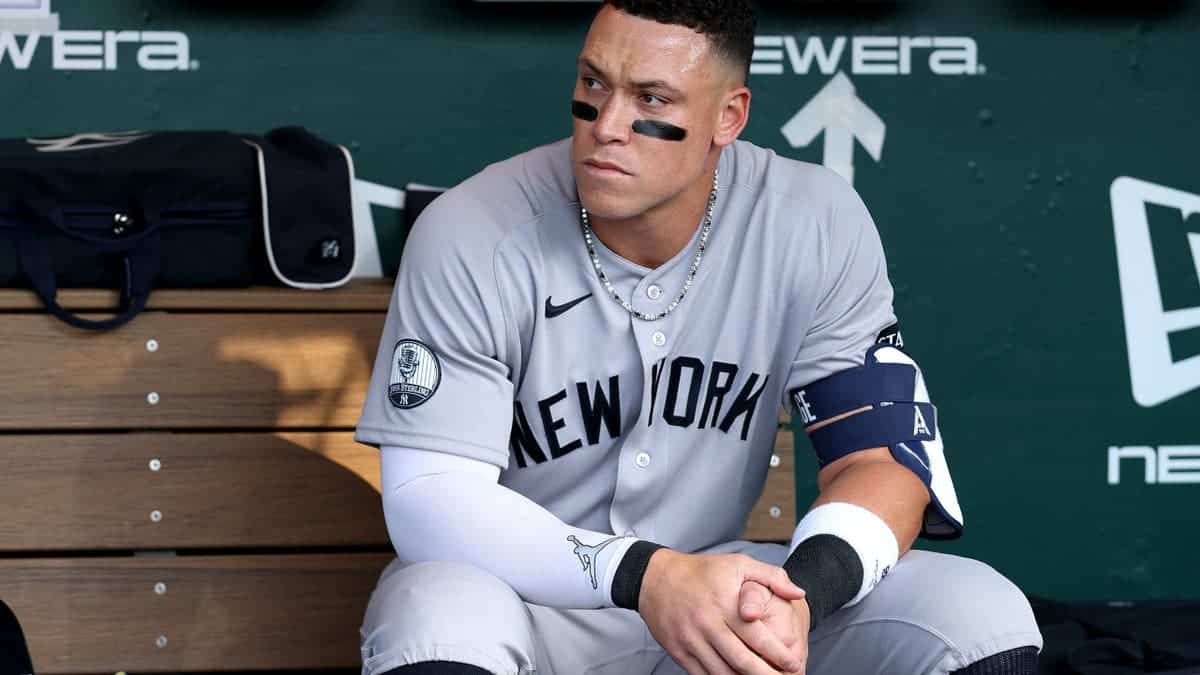 Aaron Judge sitting in the dugout wearing New York Yankees uniform.