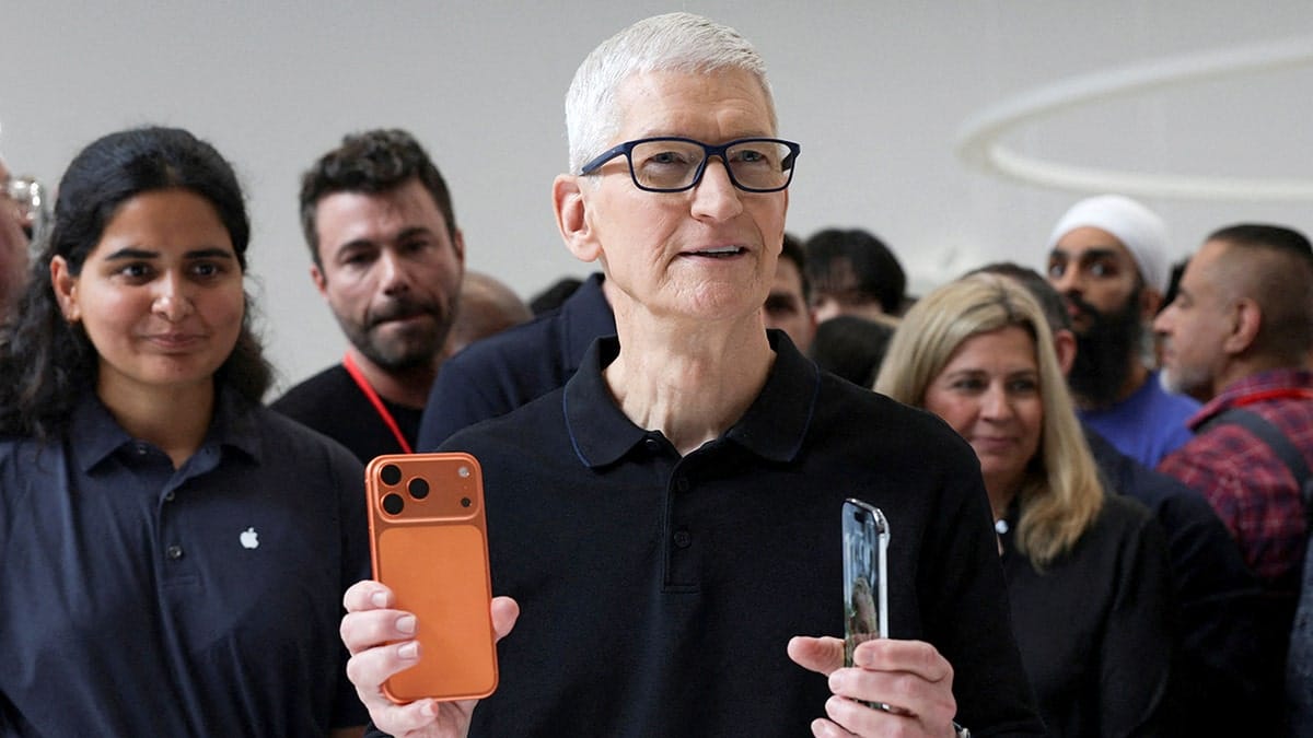 Apple CEO Tim Cook holding an iPhone 17 Pro and an iPhone Air at an event.