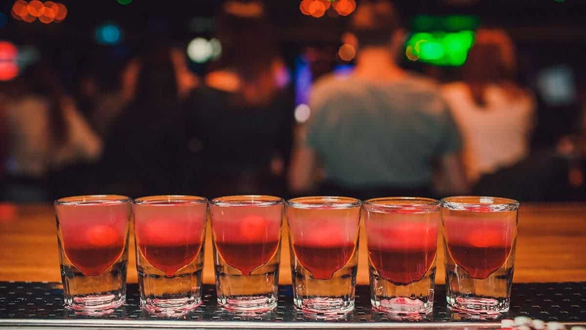Bartender pouring tequila into a glass at a bar
