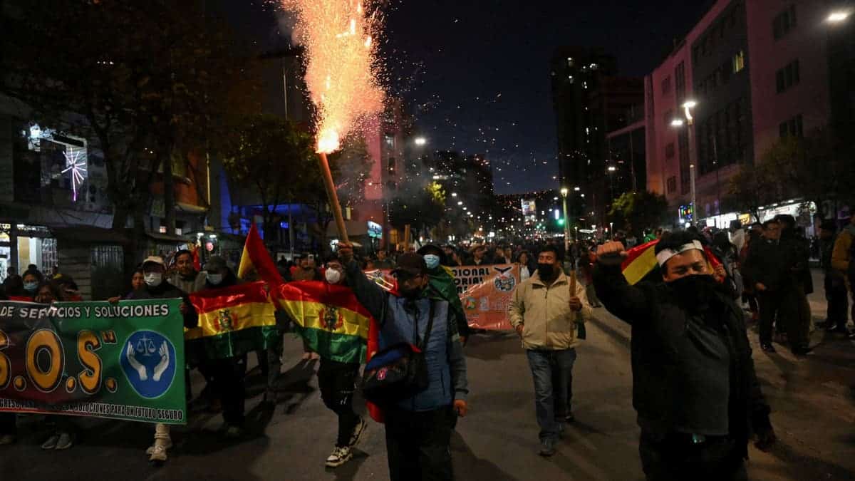 Demonstrators marching and holding signs in La Paz, Bolivia