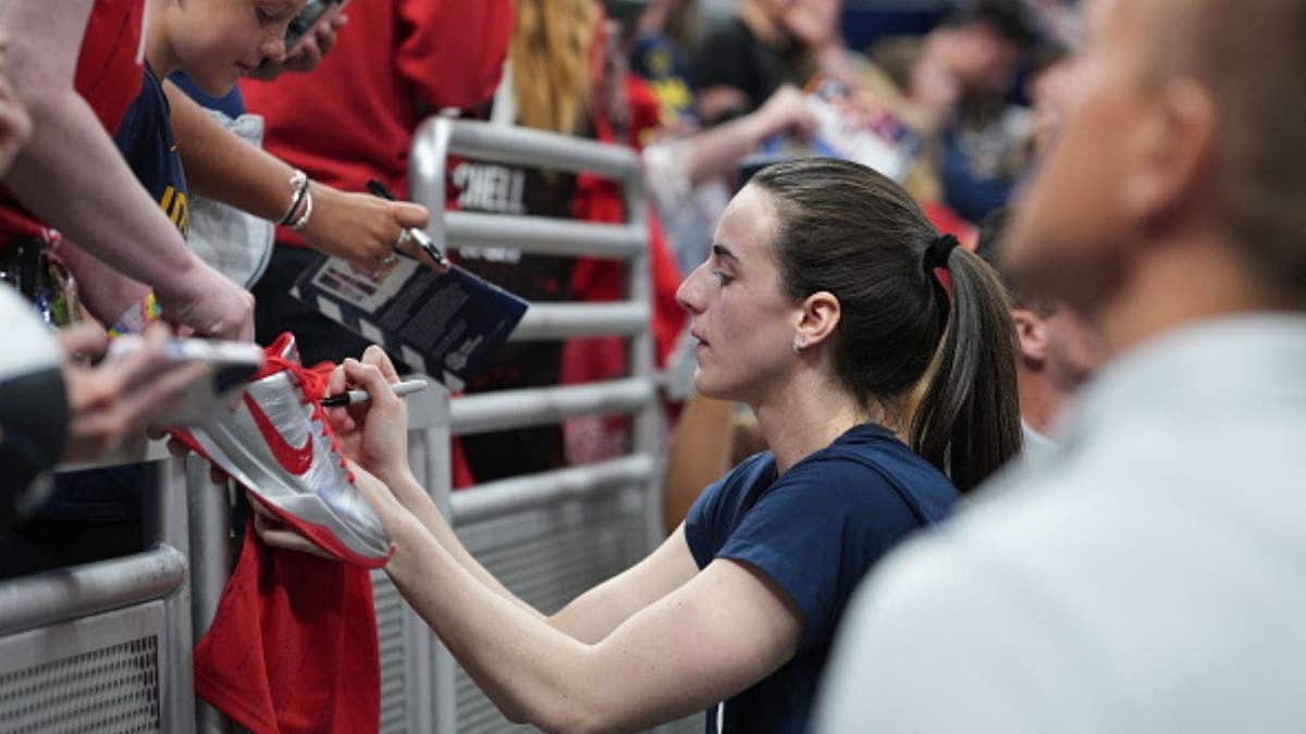 Caitlin Clark signs memorabilia for a fan before Indiana Fever’s game against Chicago Sky. (Photo by A.J. Mast/NBAE via Getty Images)