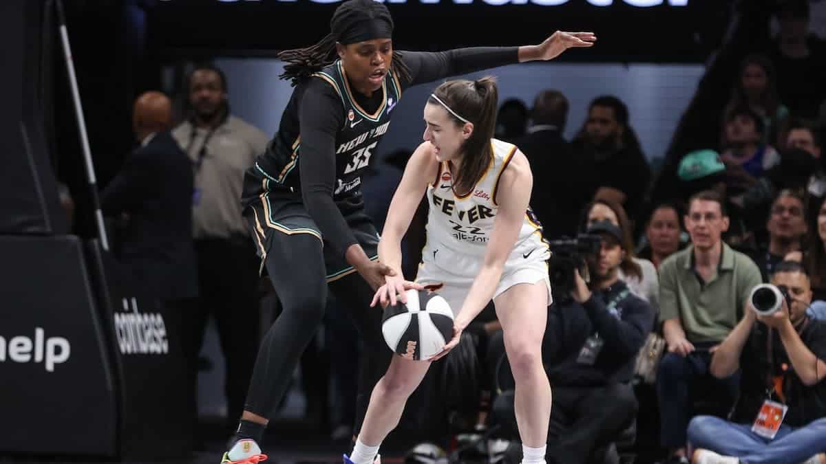 Indiana Fever guard Caitlin Clark looks to pass ball past New York Liberty center Jonquel Jones at Barclays Center