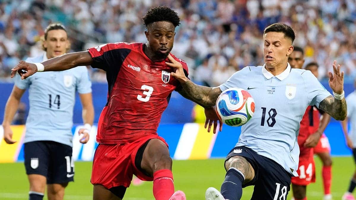 Cape Verde's Diney Borges and Uruguay's Brian Rodriguez competing for the ball in a soccer match.