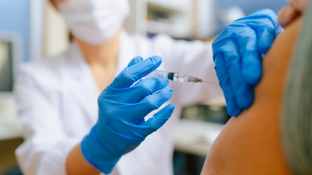 Senior adult man receiving vaccination in a doctor's office.
